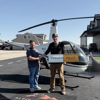 Student and instructor with a Private Pilot sign