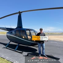 New commercial pilot beside the helicopter